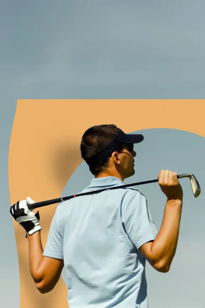 Man met golfclub over zijn schouders poseert voor een oranje grafisch element op een heldere dag.